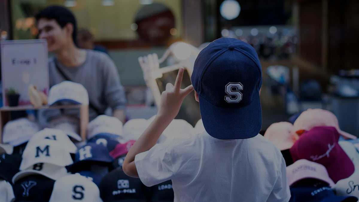 Shoppers trying on Flexfit caps at a cap wall