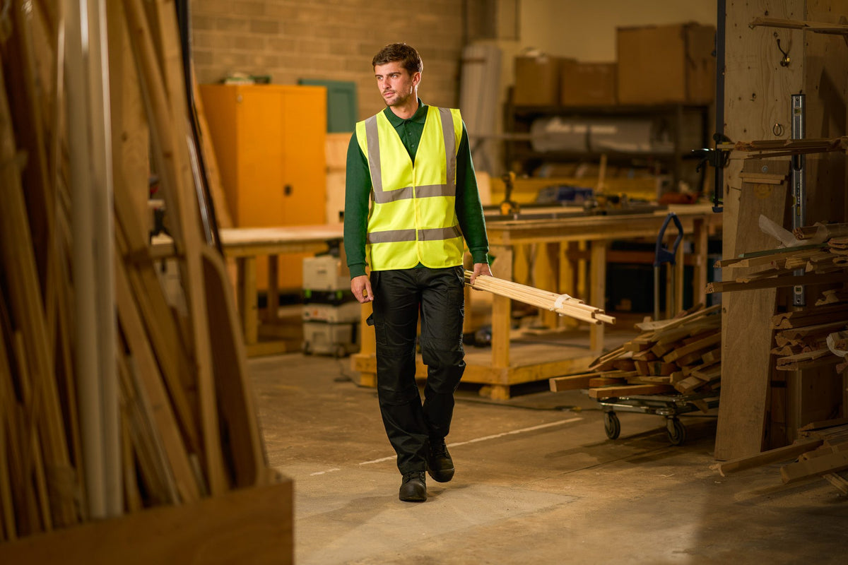 Worker in a ProRTX hi-vis vest walking through a timber workshop