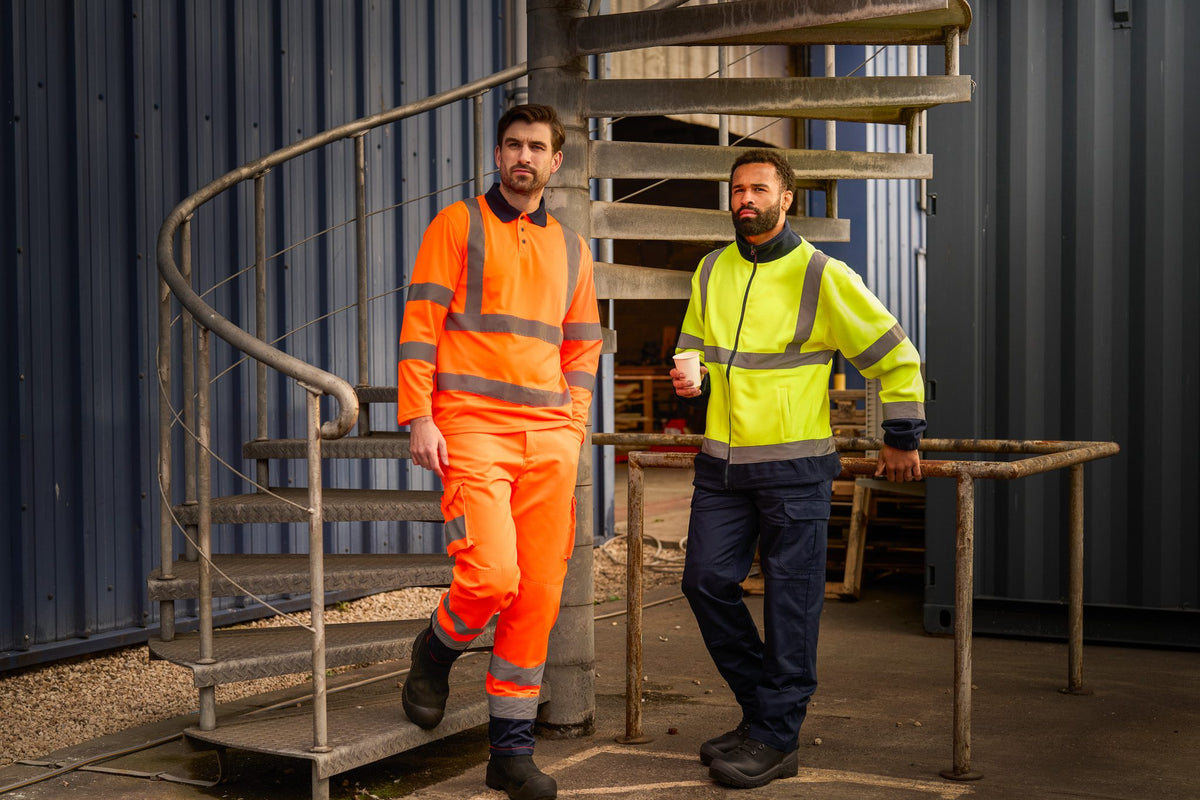 Two workers in ProRTX orange and yellow hi-vis on an industrial stairway